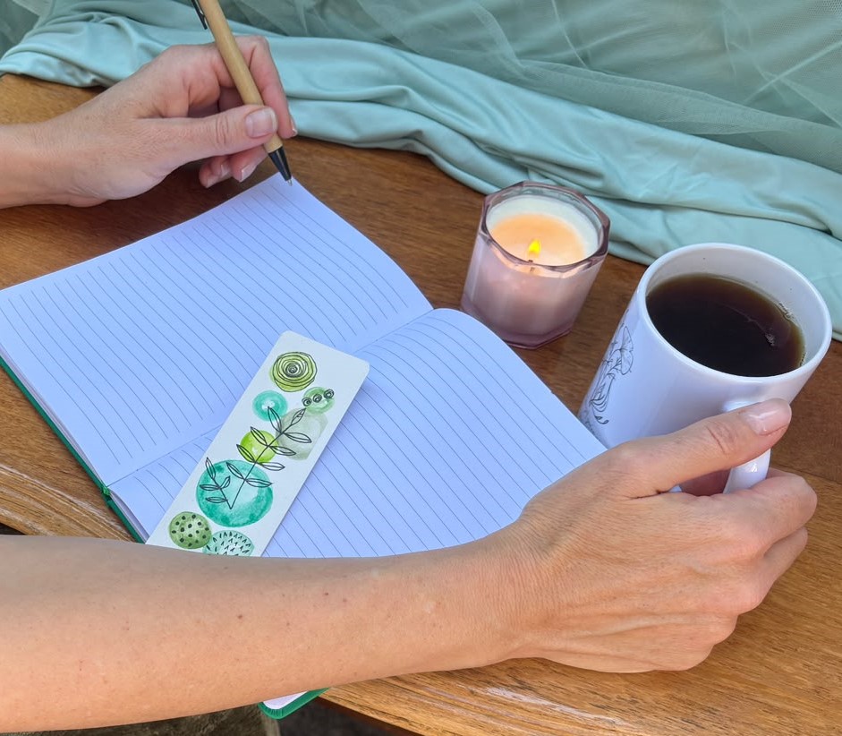 A quiet moment of reflection with a journal, tea and candle